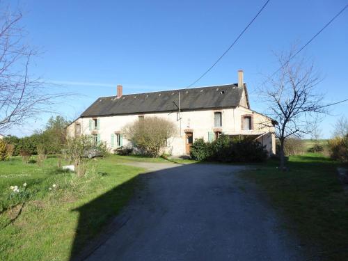 a large white house with a road in front of it at Cottage in an old remote farmhouse near Ch teauroux in Giroux