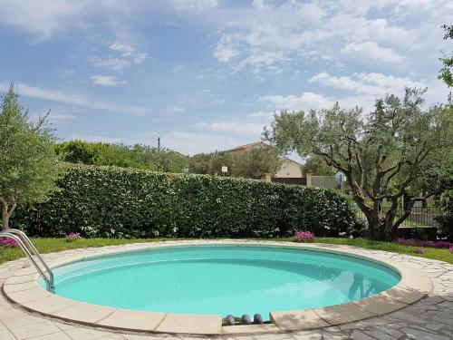 - une petite piscine dans une cour avec une haie dans l'établissement Modern villa with private pool, à Cornillon