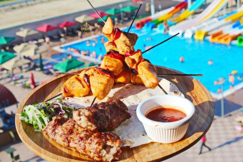 a plate of food on a table next to a pool at Spring Hotel in Novxanı