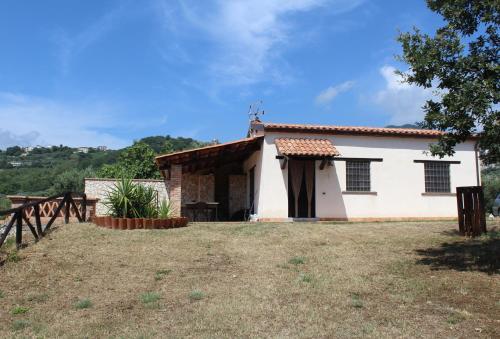 a small white house with a table in a yard at Casetta ai Malvitani in Cetraro