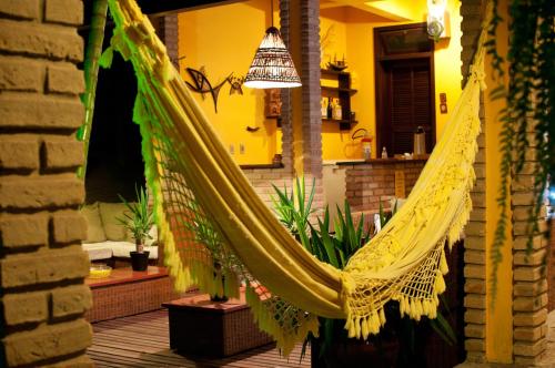 a hammock hanging in a room with plants at Pousada Canto do Rio in Prado