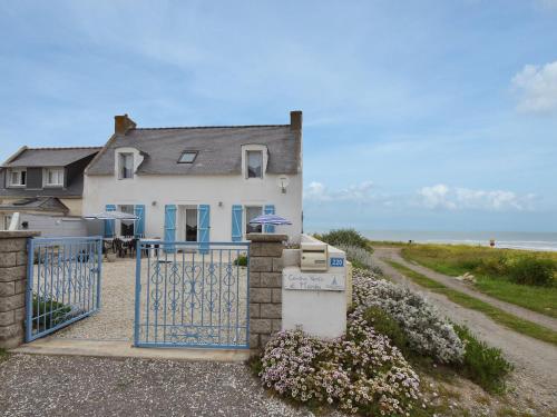 ein Haus mit einem Tor vor dem Meer in der Unterkunft Beautiful holiday home by the sea in Penmarch in Saint-Guénolé