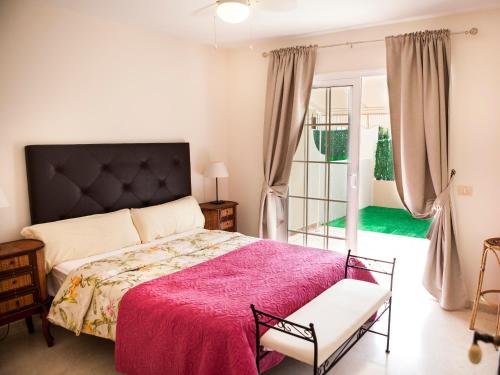 a bedroom with a large bed with a pink blanket at Duplex 2bedroom for you in Palm-Mar