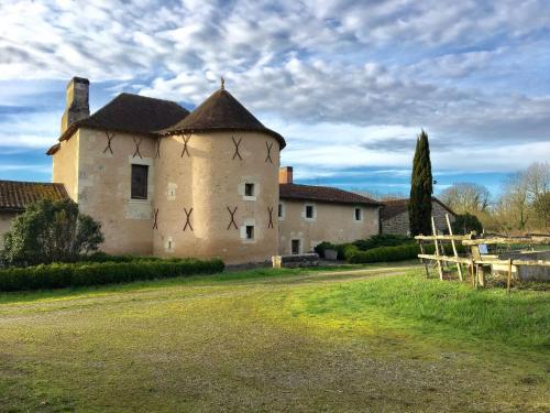 a large building with a turret on a grass field at Beautiful holiday home with private pool in Boussageau