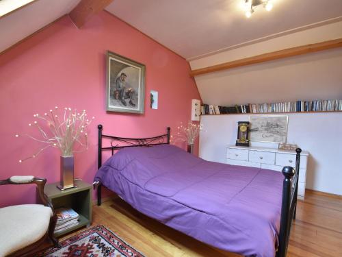 a bedroom with a bed and a pink wall at Cozy Cottage in Fresville with Garden in Fresville