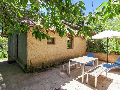 een tafel en stoelen en een parasol voor een gebouw bij Cosy Holiday Home in Bourgnac with Private Pool in Bourgnac