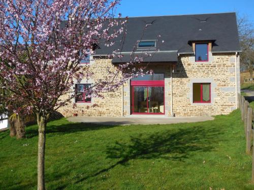 una casa di mattoni con un albero di fronte di Modern Cottage in Normandy with Large Garden a Isigny-le-Buat