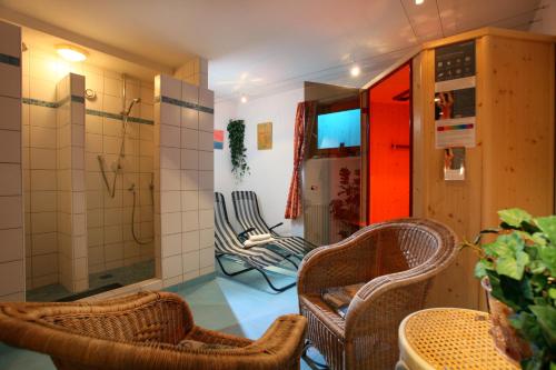 ein Bad mit 2 Stühlen und einer Dusche in einem Zimmer in der Unterkunft Pension Brixana in Brixen im Thale