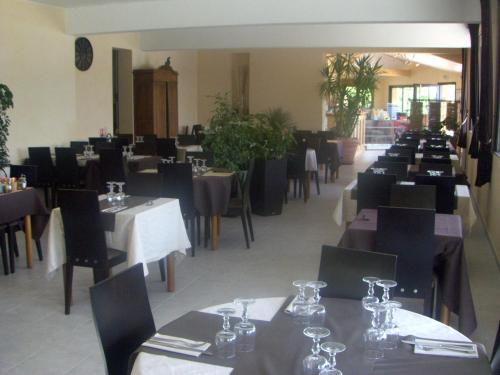 une salle à manger dotée de tables et de chaises avec table dans l'établissement Camping La Motte Flottante, à La Freissinouse