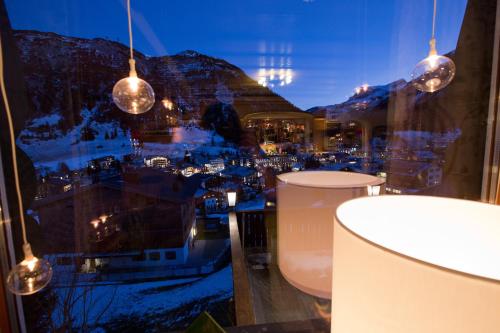 a view of a city from a window with lights at Hotel Angela in Lech am Arlberg