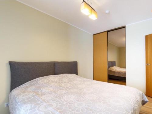 een slaapkamer met een bed en een spiegel bij Papli 34 Apartment with pool in Pärnu