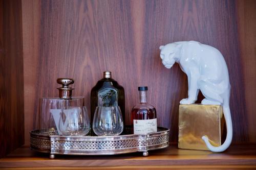 a shelf with bottles and a statue of a cat at Hotel Angela in Lech am Arlberg
