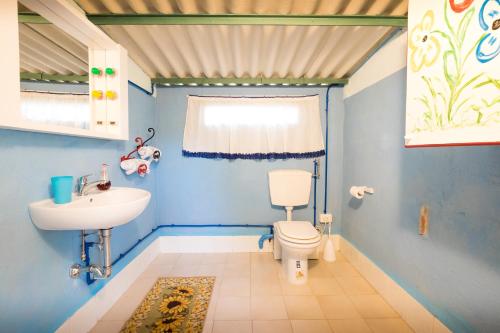 a blue bathroom with a toilet and a sink at Impronta di Gaia in Foiano della Chiana