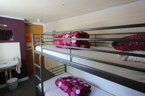 a room with two bunk beds with pink pillows at Skye Backpackers in Kyleakin
