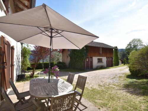a table with an umbrella on a patio at Holiday home in Saulxures sur Moselotte in Saulxures-sur-Moselotte