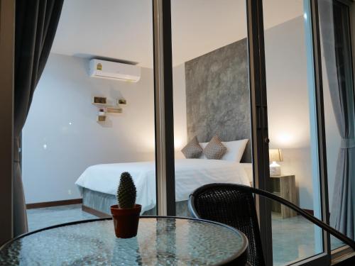 a room with a glass table and a bed at Marisa Garden Bungalow in Bang Tao Beach