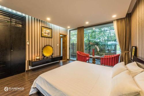 a bedroom with a large white bed and a balcony at FLAMINGOS Villa Happy 3 phòng ngủ- view Hồ- bể bơi riêng in Ngọc Quang