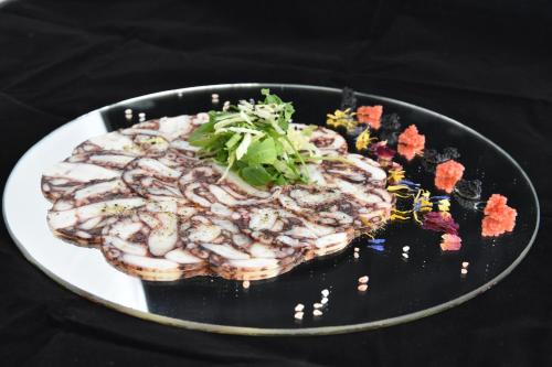 a plate of food on a black plate with food at Hotel Vidikovac in Zvornik