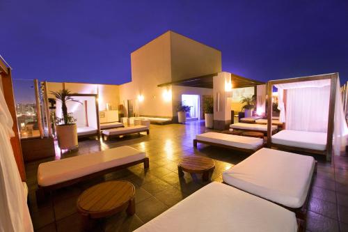 a room with couches and tables on top of a building at Radisson Hotel Decapolis Miraflores in Lima