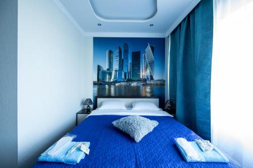モスクワにあるLadomir v Borisovoのベッドルーム1室(市街のスカイラインを望む青いベッド1台付)