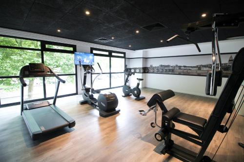 a gym with treadmills and exercise equipment in a room at Hotel Mercure Blois Centre in Blois