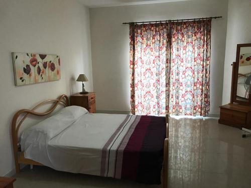 Schlafzimmer mit einem Bett und einem Fenster in der Unterkunft Bugibba Homes Suite in St Paul's Bay
