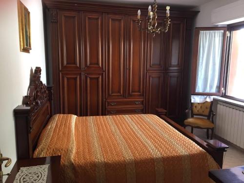 Un dormitorio con una cama con paredes de madera y una lámpara de araña. en Appartamento Biancospino, en Gualdo Tadino