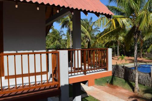 a porch of a resort with a swimming pool at The Coconut Gardens Hotel & Restaurant in Tissamaharama