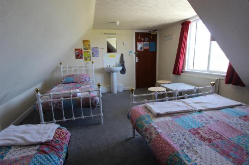 a bedroom with two beds and a sink at Skye Backpackers in Kyleakin