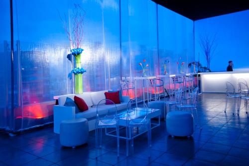 a room with a couch and tables and chairs at Radisson Hotel Decapolis Miraflores in Lima
