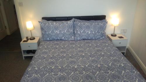 a bedroom with a bed with two nightstands and two lamps at Smart Town Centre Apartments in Northampton