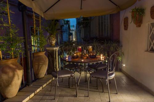 a table and chairs on a balcony with plants at Casa Latina in Naples