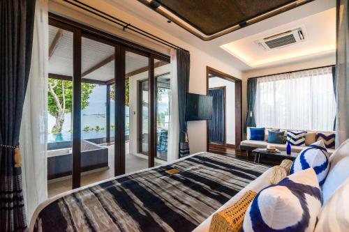 a hotel room with a large bed and a large window at Peace Resort Samui - SHA Extra Plus in Bophut