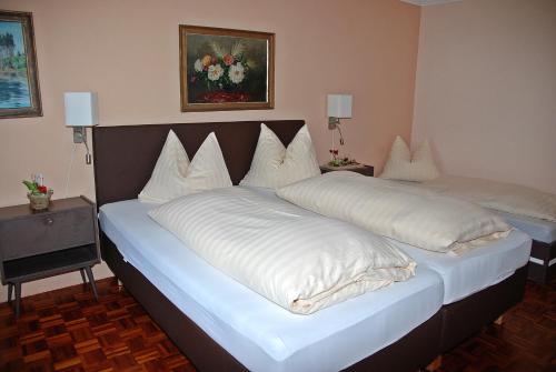 two beds with white blankets and pillows in a room at Pension Weber in Tamsweg