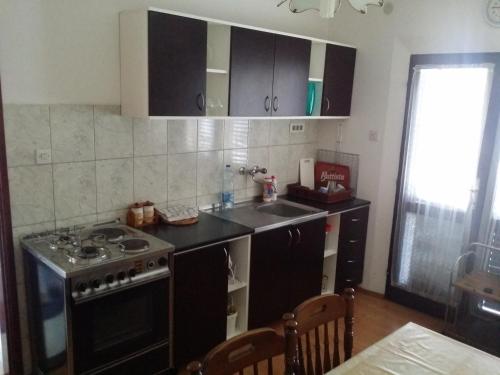 a kitchen with a stove and a sink in it at Apartman Tripkovic in Bar