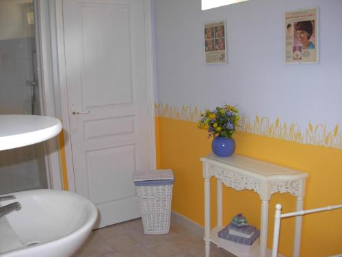 een badkamer met een wastafel, een toilet en een tafel bij Les Basses Besmes in Parcé
