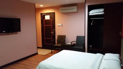 a hotel room with a bed and a tv and a bedroom at Hotel Sadong88 in Kota Kinabalu