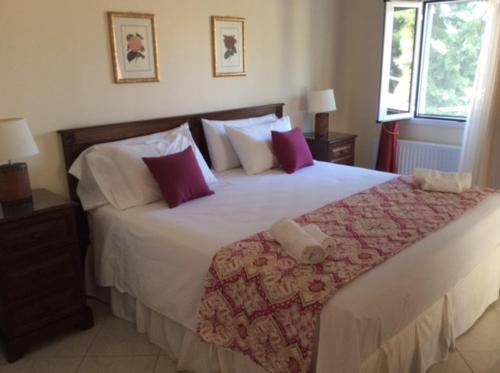 ペルディカにあるPerdika Suitesのベッドルーム1室(紫と白の枕が備わる大型ベッド1台付)