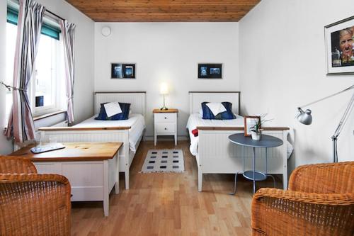 Zimmer mit 2 Betten, einem Tisch und Stühlen in der Unterkunft Abbekås Golfrestaurang & Hotell in Abbekås