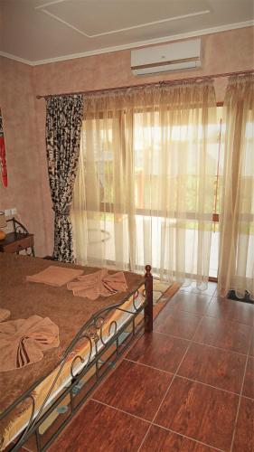 a bedroom with a bed and a window with curtains at Villa Sosnovy Bor in Zatoka