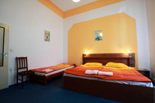 a bedroom with two beds and a chair at Hotel Club in Vranovská Ves