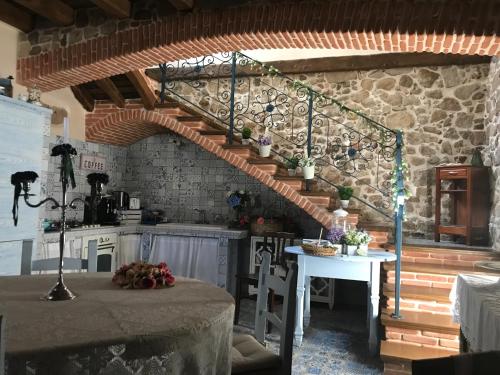a kitchen with a spiral staircase in a stone wall at Vesta in Sorgono