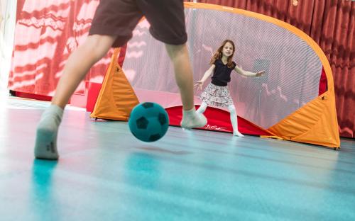 a young girl playing with a soccer ball in a gym at Hôtel Ermitage in Évian-les-Bains