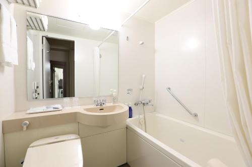 a bathroom with a sink, toilet and bathtub at Hotel Hokke Club Osaka in Osaka