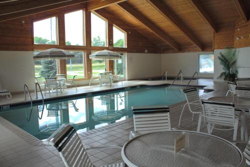 einen Pool mit Stühlen und Tischen in einem Gebäude in der Unterkunft Americas Best Value Inn in Annandale