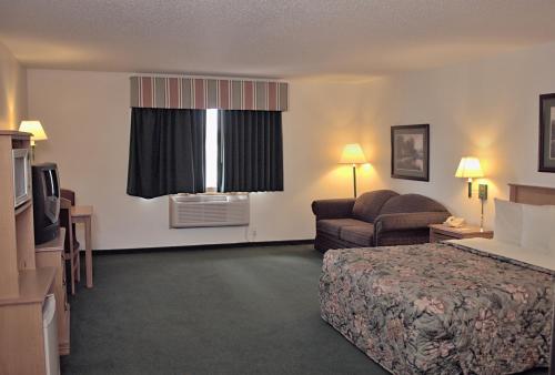a hotel room with a bed and a couch at Americas Best Value Inn in Annandale