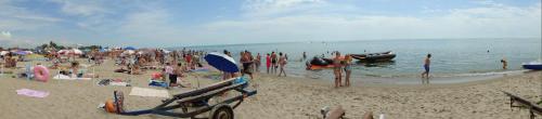 a group of people on a beach with the ocean at Villa Sosnovy Bor in Zatoka