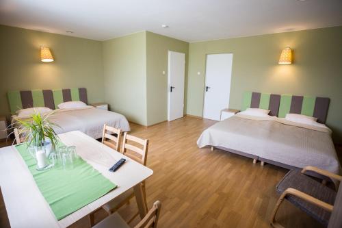 a room with two beds and a table and chairs at Irbēni in Brivkalni
