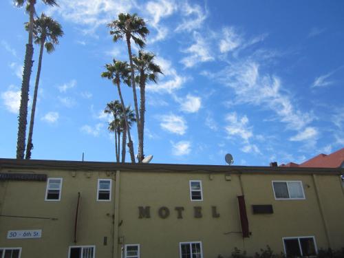 a motel building with palm trees in the background at Civic Center Lodge / Lake Merritt BART in Oakland