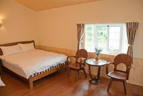 鹿谷的住宿－林家莊民宿，一间卧室配有一张床、一张桌子和一个窗户。